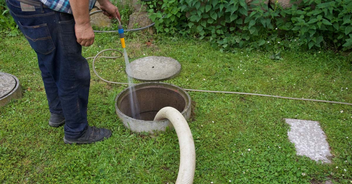 What Is the Best Chemical to Put in a Septic Tank? How Do I Increase Good Bacteria in My Septic Tank? 1 Person maintaining a septic tank by flushing water into the system, ensuring proper waste management.