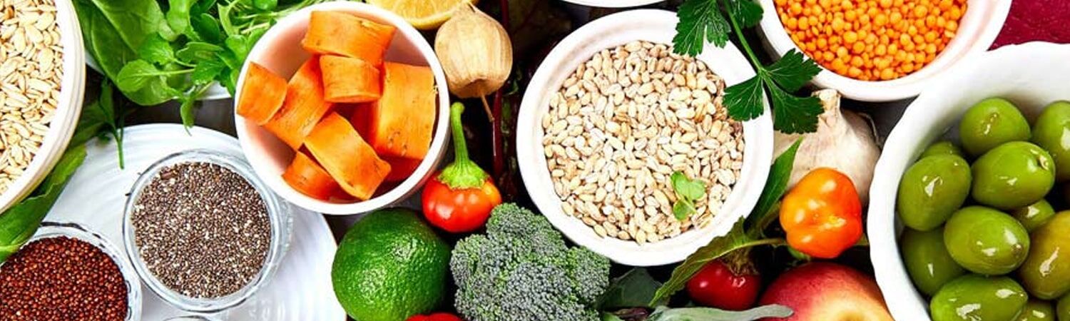Bringing Nature's Magic To Help Plants Grow And Prosper 1 A top-down view of a colorful spread of healthy foods, including fresh vegetables, lentils, grains, nuts, and olives.