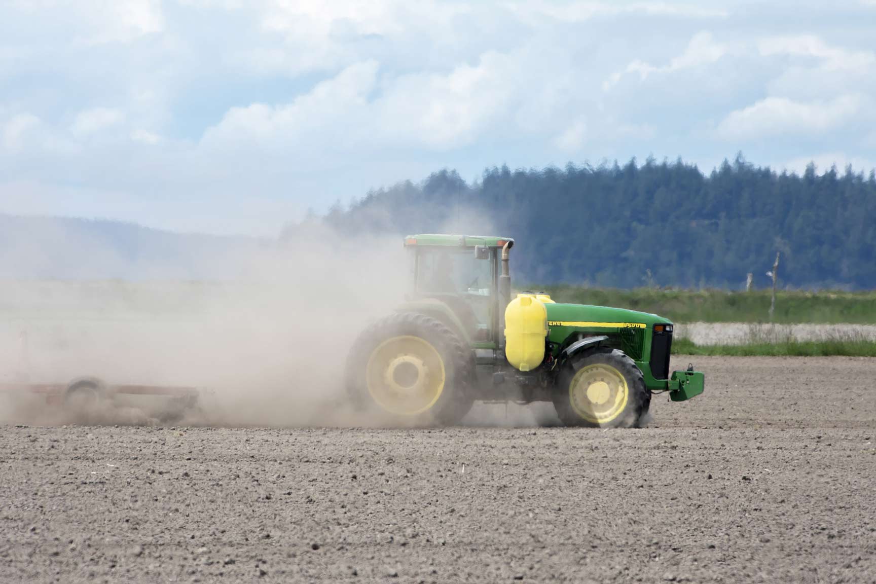 How Farmers Can Combat Erratic Weather Conditions Using Magic Gro Plus 1 A green tractor working in a field, representing agricultural technology and modern farming practices that can be enhanced to combat erratic weather conditions.