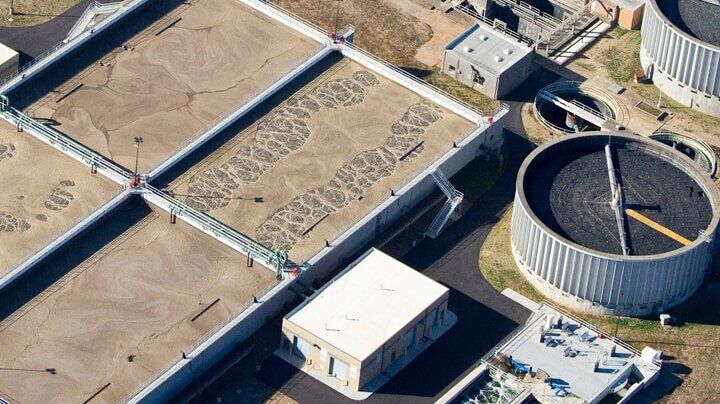 Industrial Wastewater Treatment: Who Requires It? 1 Aerial shot of an industrial wastewater treatment plant with multiple large aeration basins and circular clarifiers.