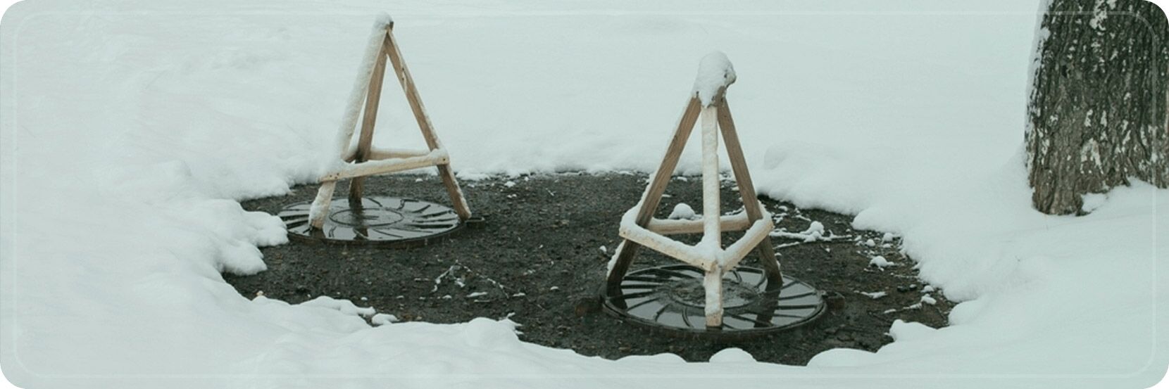 An Essential Guide for Septic Tank Usage: Common Winter Problems and Resolution 1 Snow-covered septic tank area with protective covers, highlighting common winter problems in septic systems.