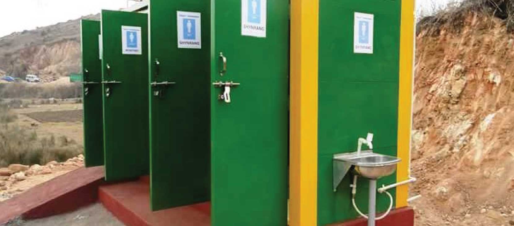 Bio-Toilets: Sanitation Super Hero To Our Rescue 1 Green bio-toilet units with a washbasin, set in a rural area, promoting eco-friendly sanitation solutions.