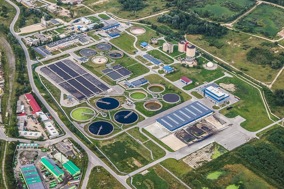Why Innovative Wastewater Treatment Solutions Are Urgently Needed In India 1 Aerial view of a wastewater treatment plant with circular tanks and green pipes