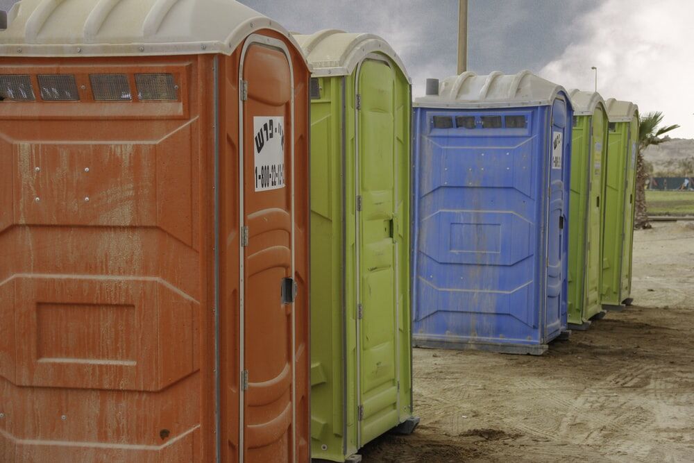 Bio-toilets Transforming the Indian Sanitation 1 Row of portable bio-toilets in various colors at an outdoor site, promoting improved sanitation in India.