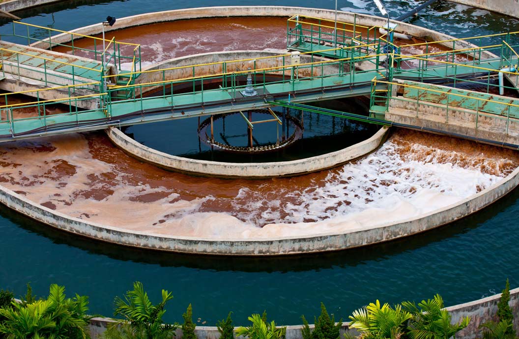 A Peek into the History of Wastewater Treatment 1 Aerial view of a wastewater treatment plant with circular tanks, walkways, and aeration systems.