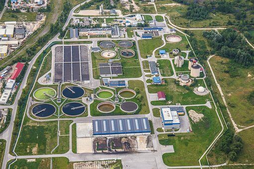 How Can Municipal Wastewater Treatment Help In Reducing Water Pollution 1 Aerial view of a municipal wastewater treatment plant with tanks anf green surroundings.