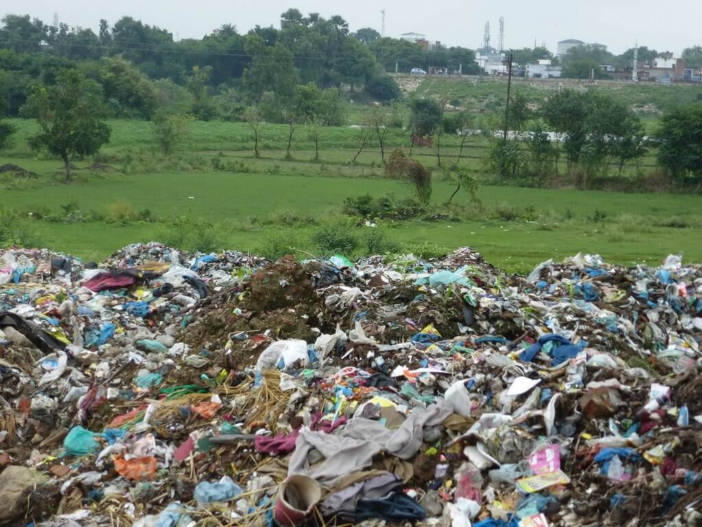 Negative Effects of Improper Solid Waste Disposal on Human Health 1 Large pile of improperly disposed solid waste polluting open green land.